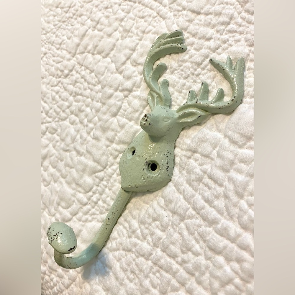 Painted metal hook in shape of dear head with antlers. Approximately 8” long.